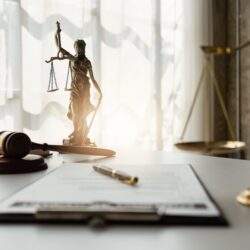 desk with clipboard, gavel & different scales on it